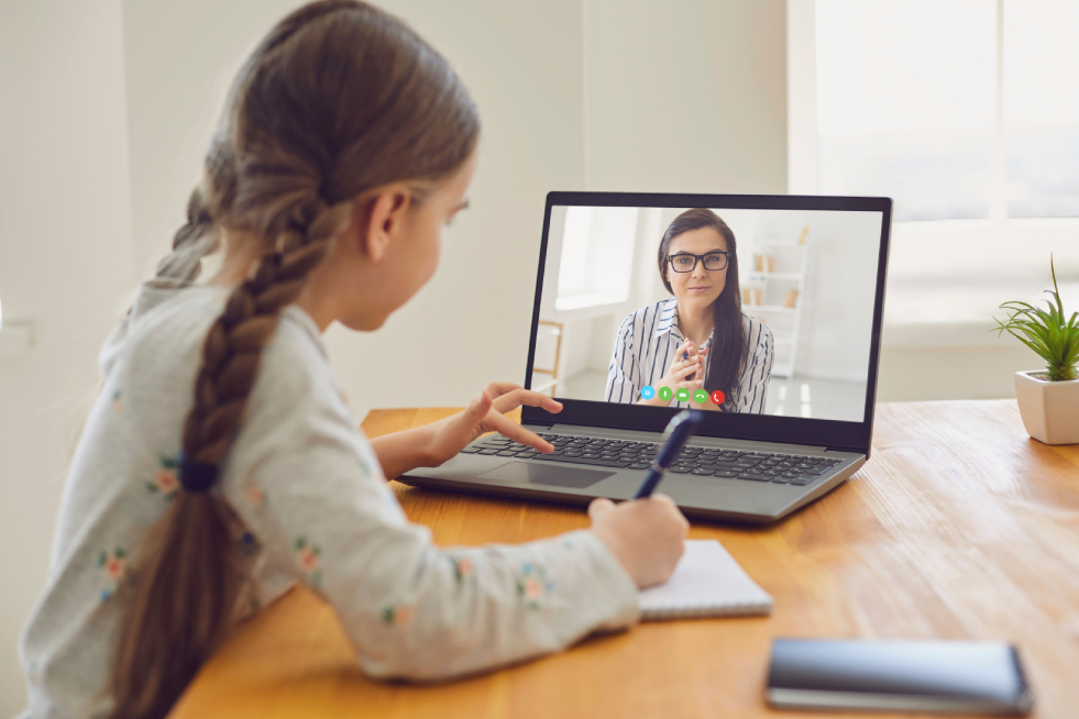 Little girl attending an online classroom